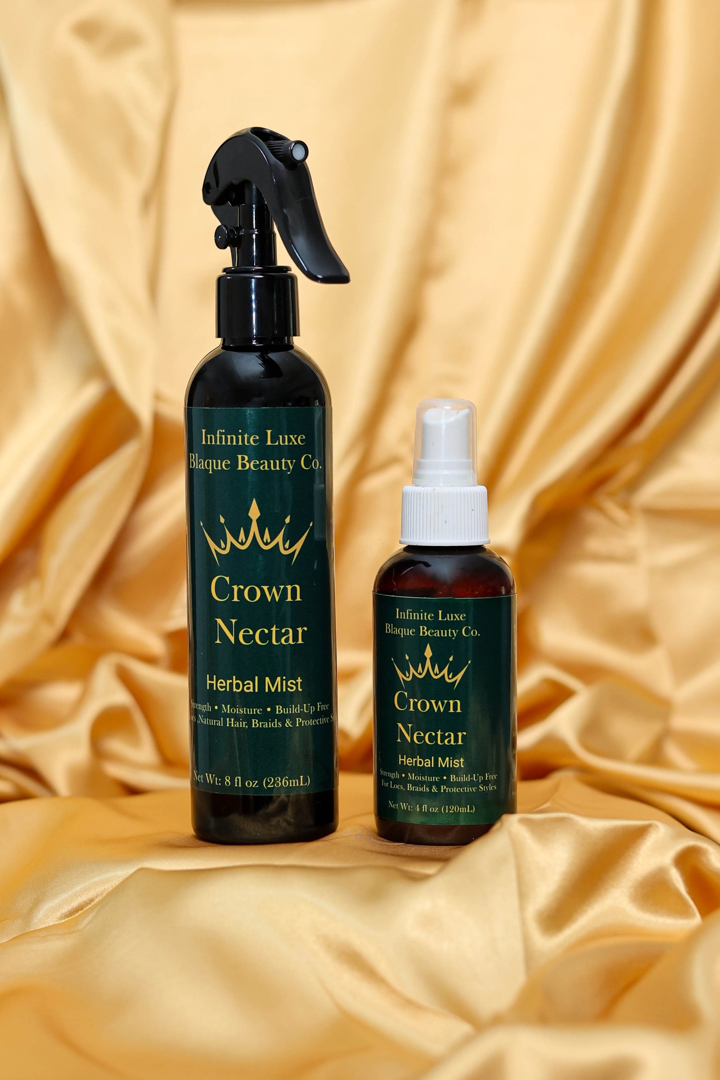 Two bottles of Crown Nectar Herbal Mist on a gold fabric background