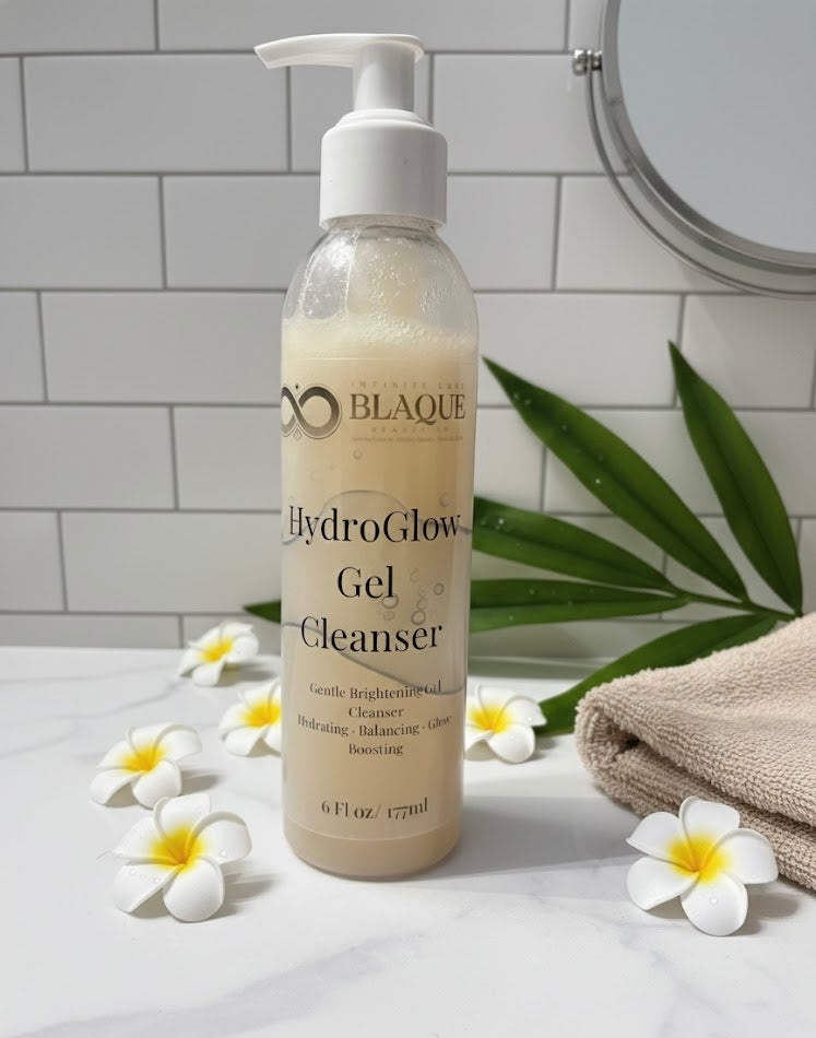 Bottle of HydroGlow Gel Cleanser on a bathroom counter with flowers and a towel