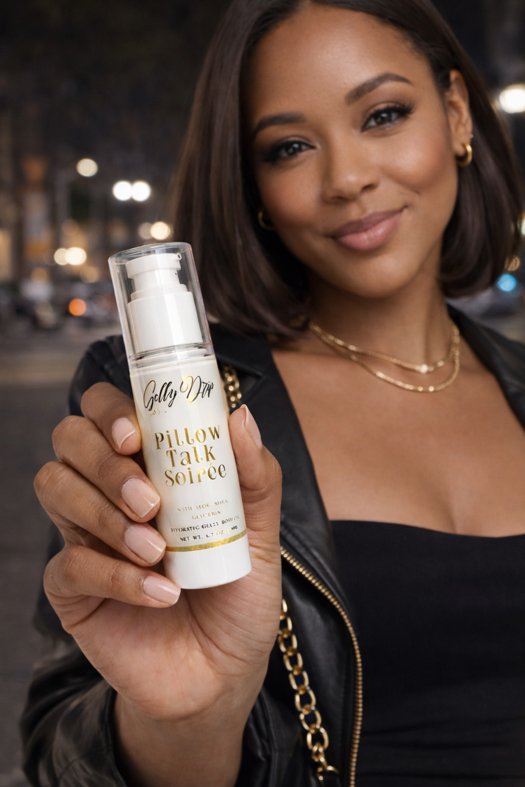 Woman holding a bottle of 'Gilly Dirt' Pillow Talk Serum with a blurred city street background